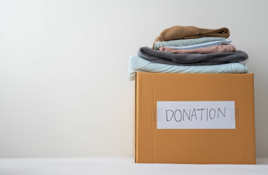 A brown donation box filled with old clothes to be donated