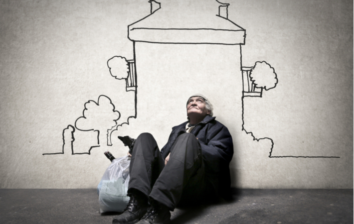 Man with bags sitting down next to house cartoon on wall