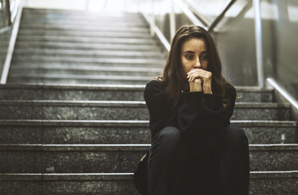 Woman Sitting Look Worried on The Stairway due to homelessness