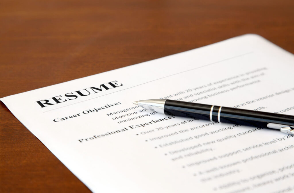 A close-up of a resume with a pen on the table.