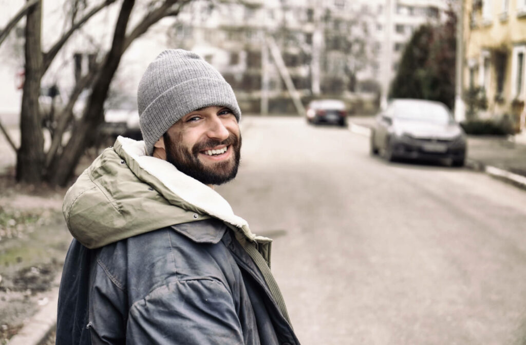 A young person experiencing homelessness smiling and looking healthy