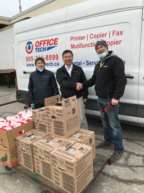 a volunteer accepting a corporate food donation from Office tech, a business in brampton 