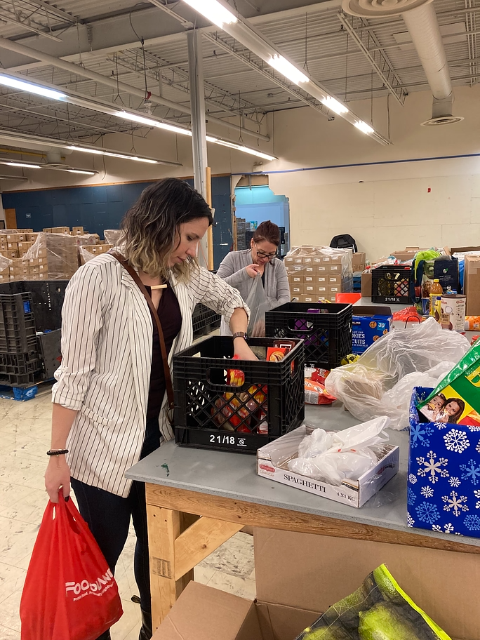 a volunteer putting food donations into a milk crate at regeneration brampton