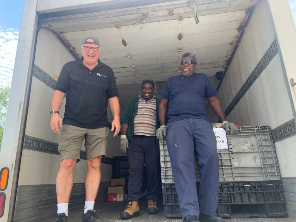 3 volunteers smile in a truck preparing to pick up food to aid in Regeneration Brampton's food rescue 