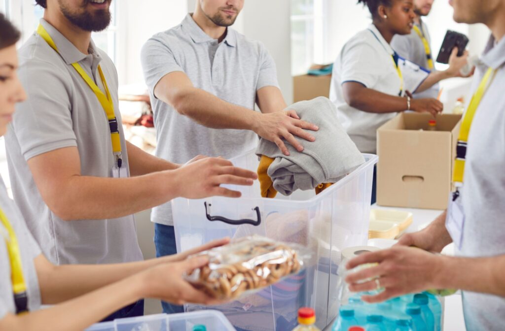 Volunteers organize food, clothing, and supplies for distribution at a donation center.