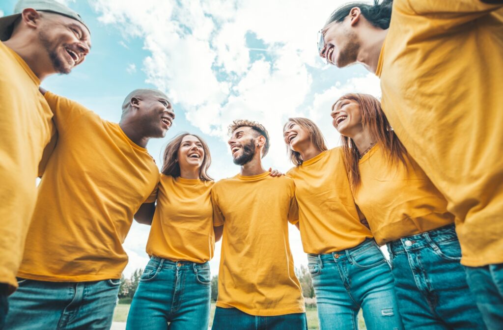Group of volunteers standing in a semi-circle smiling at each other